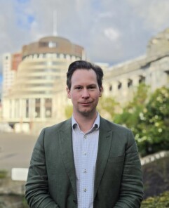 Adam Allington with the Beehive behind him